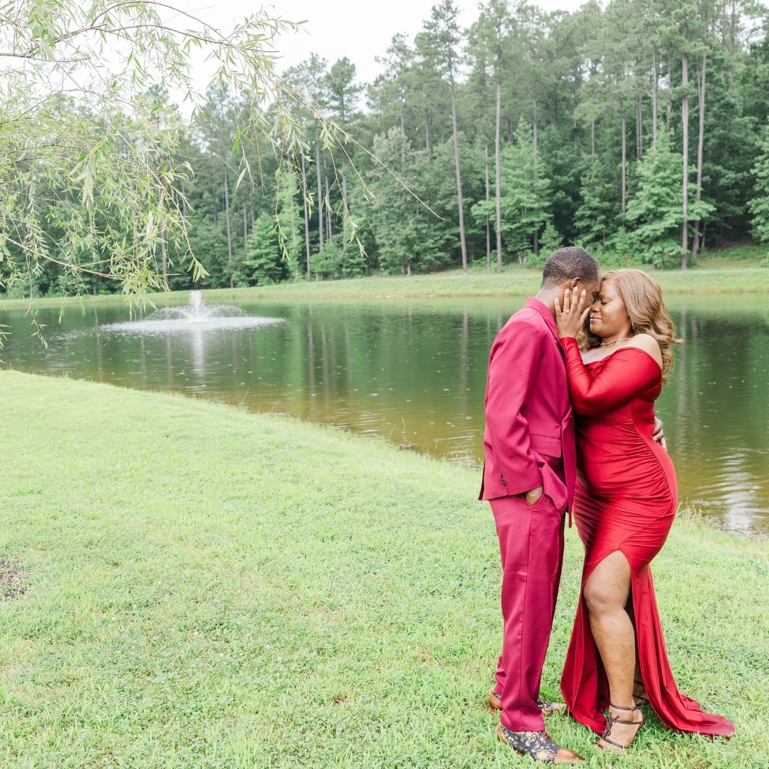 The couple kissing in front of the beautiful pond on the pinehill pavilion pond. 